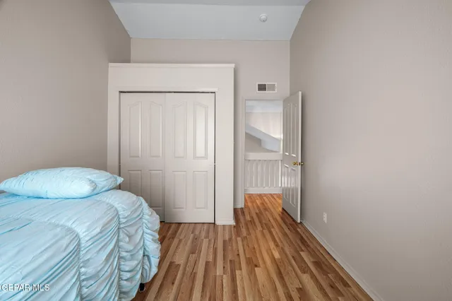 a bedroom with a bed and wooden floor