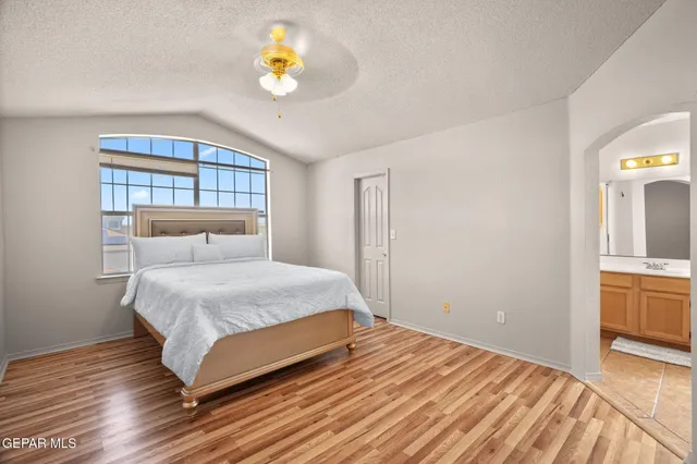 a bedroom with a bed and painting on the wall