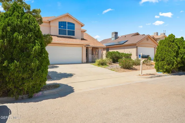 a front view of a house with a yard and a garage
