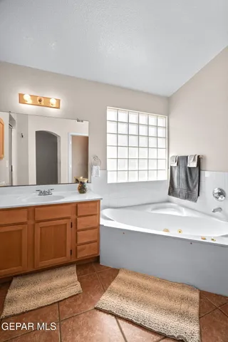 a spacious bathroom with a tub double vanity sink and a large mirror