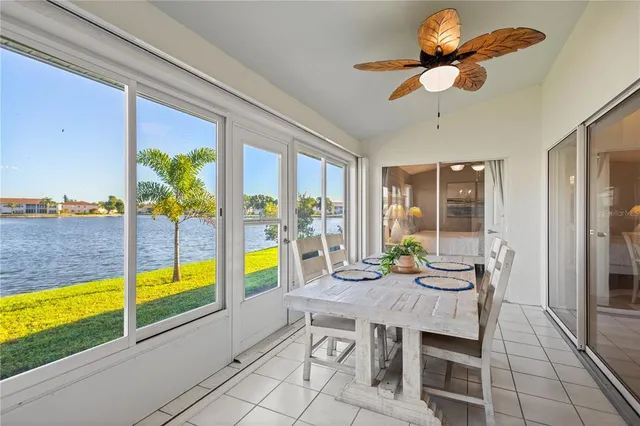 a view of a dining room with furniture a chandelier and large windows