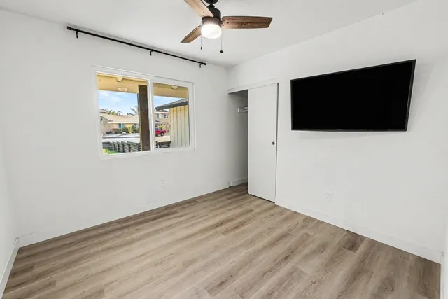en empty room with wooden floor and windows