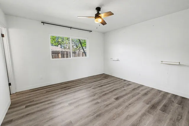 wooden floor in an empty room with a window
