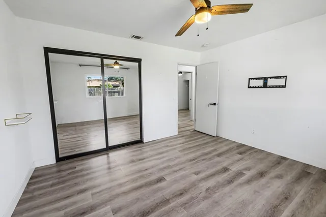 a view of an empty room with wooden floor
