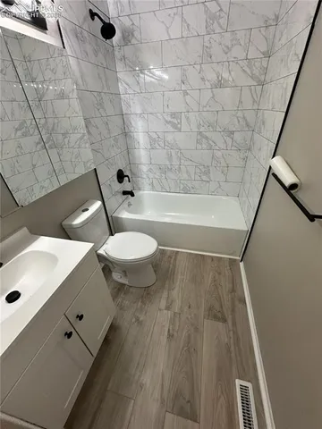 a bathroom with a toilet a sink and bathtub