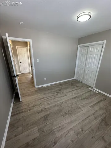 a view of an empty room with wooden floor