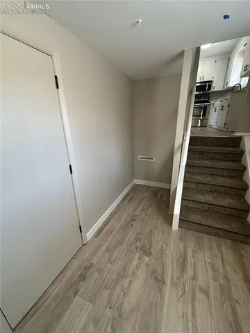 a view of entryway and hall with wooden floor