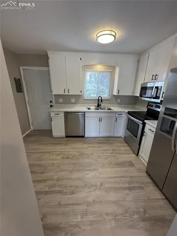 a large kitchen with a stove top oven sink and cabinets