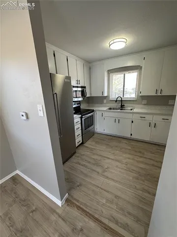 a large kitchen with a sink a refrigerator a stove a microwave and cabinets