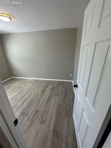 an empty room with wooden floor and entrance