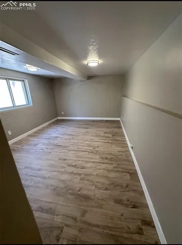 a view of empty room with wooden floor