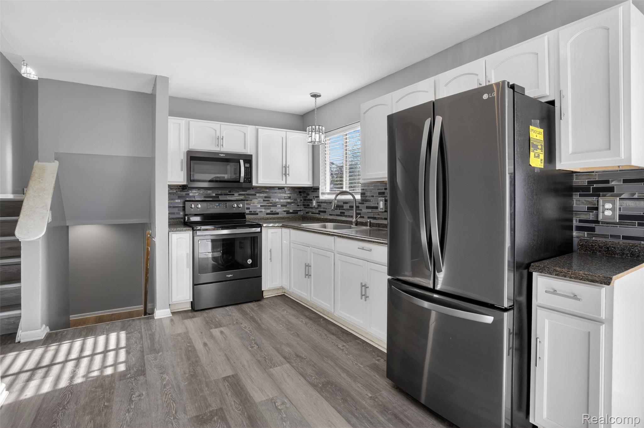 6169 Neff Road Mount Morris, MI 48458 - Photo 28 of 49 Kitchen featuring stainless steel appliances, white cabinetry, pendant lighting, and dark wood-style floors
