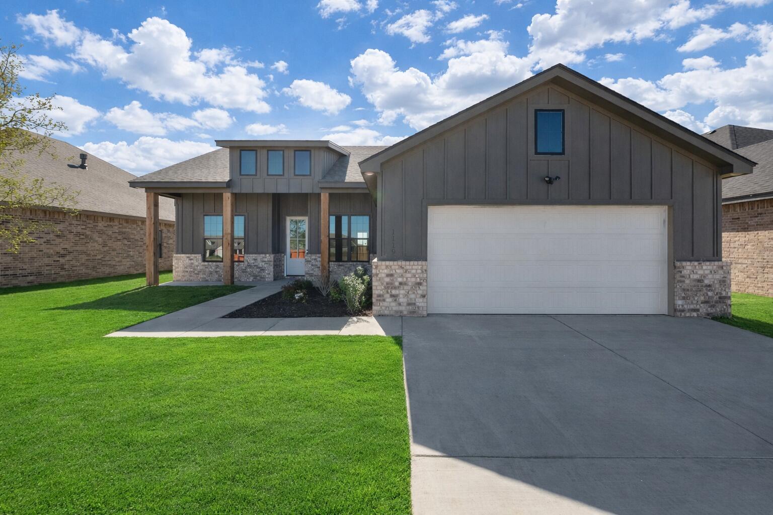 a view of a house with a yard and a garage