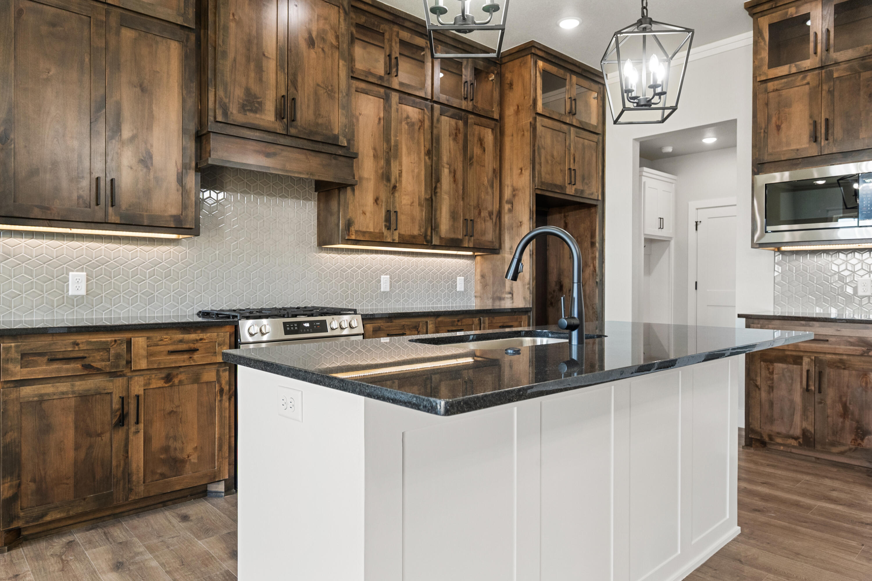 1119 North 6th Street Wolfforth, TX 79382 - Photo 13 of 37 a kitchen with stainless steel appliances granite countertop a sink a stove and a refrigerator