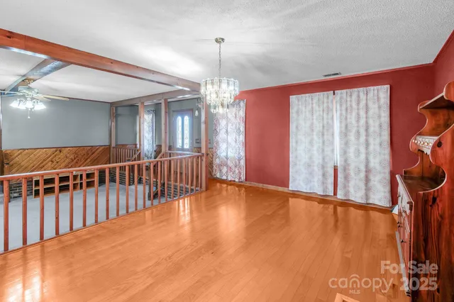 a view of an empty room with window chandelier fan