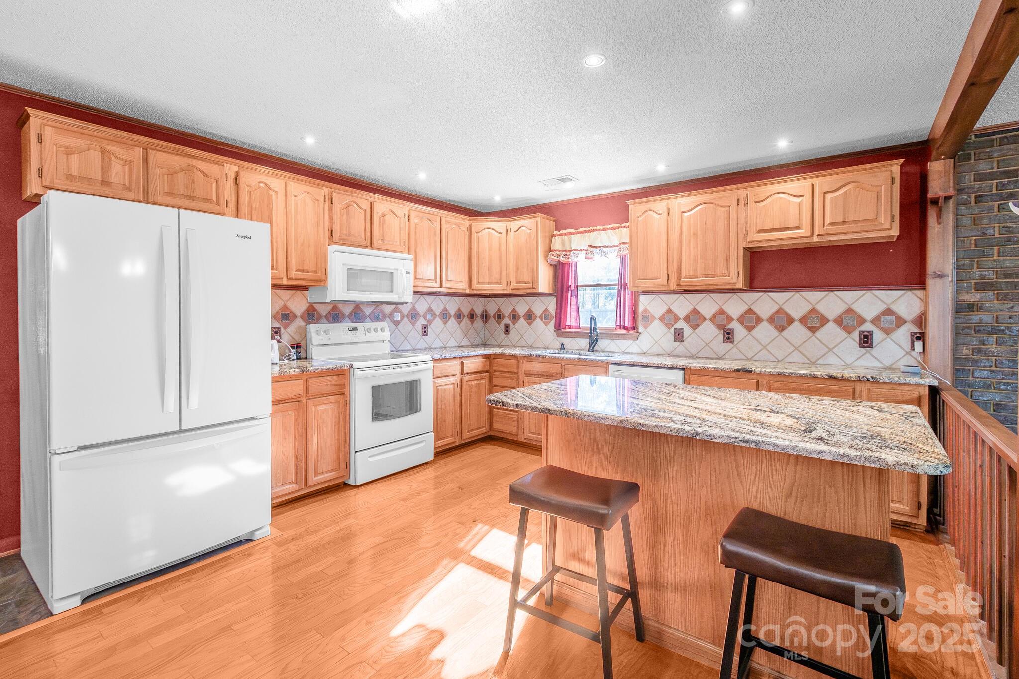 1295 Cattle Ridge Road Cheraw, SC 29520 - Photo 9 of 24 a kitchen with stainless steel appliances granite countertop a refrigerator a sink dishwasher a stove with white cabinets and wooden floor