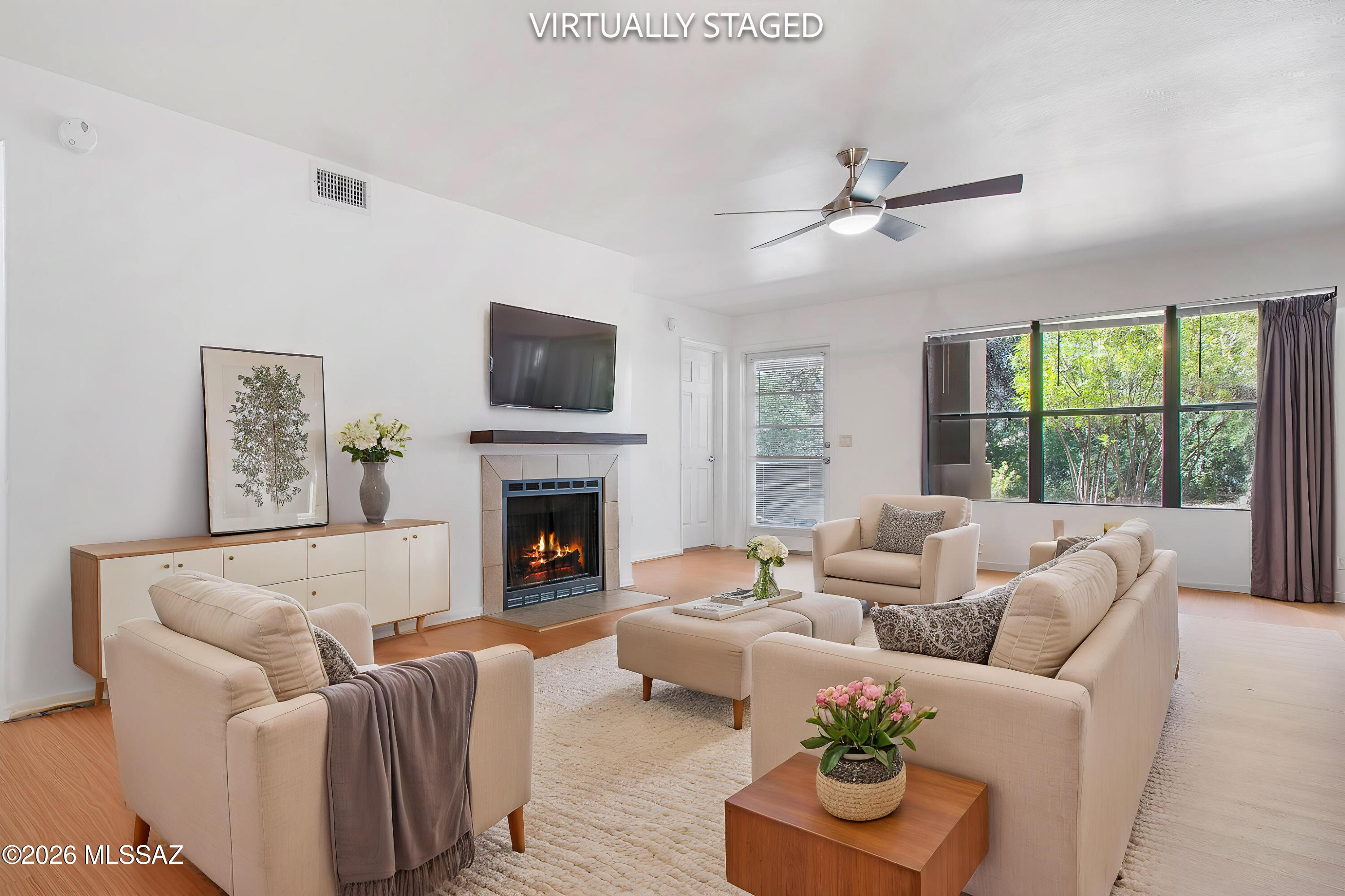 a living room with furniture fireplace and a large window
