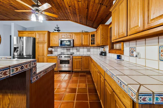 a living room with hard wood flooring and stainless steel appliances