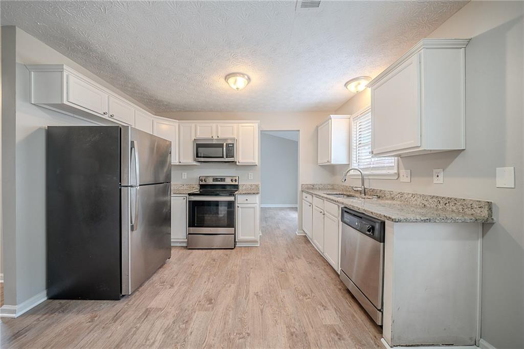 2183 Ramblewood Circle Decatur, GA 30035 - Photo 2 of 37 a kitchen with granite countertop a refrigerator stove top oven and sink