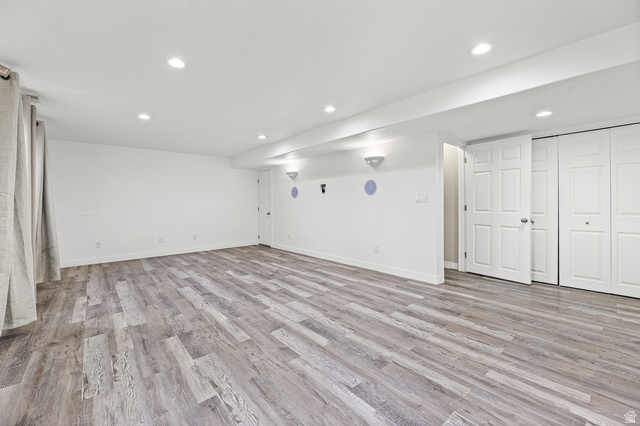 5525 Hampton Way Stansbury Park, UT 84074 - Photo 22 of 35 Spacious room featuring wood-finish flooring, recessed lighting, white walls, and bi-fold closet doors