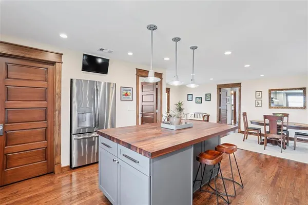 a kitchen with stainless steel appliances kitchen island granite countertop a refrigerator and a stove top oven