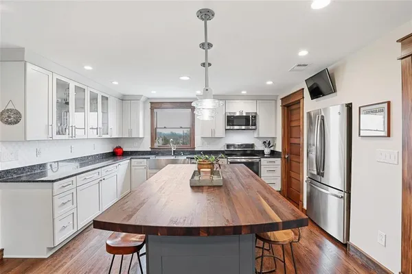 a kitchen with counter space dining table and stainless steel appliances