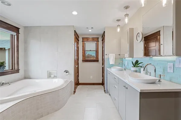 a bathroom with a granite countertop sink mirror and bathtub