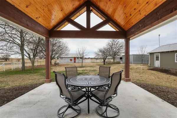 a view of a patio with a table chairs and a backyard