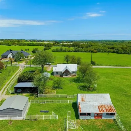 an aerial view of a house with a big yard