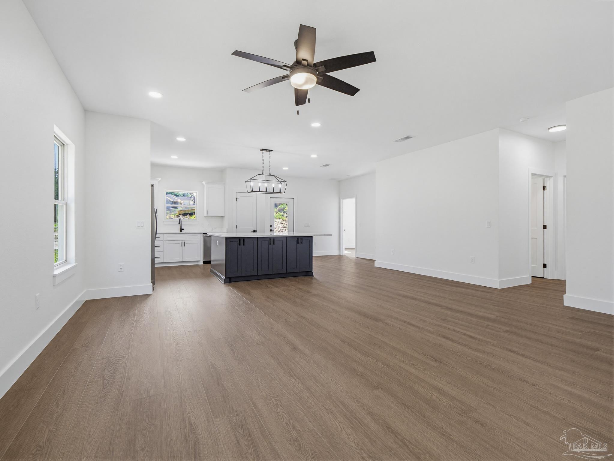 5724 Riviera Drive Milton, FL 32583 - Photo 13 of 52 a view of empty room with wooden floor and ceiling fan