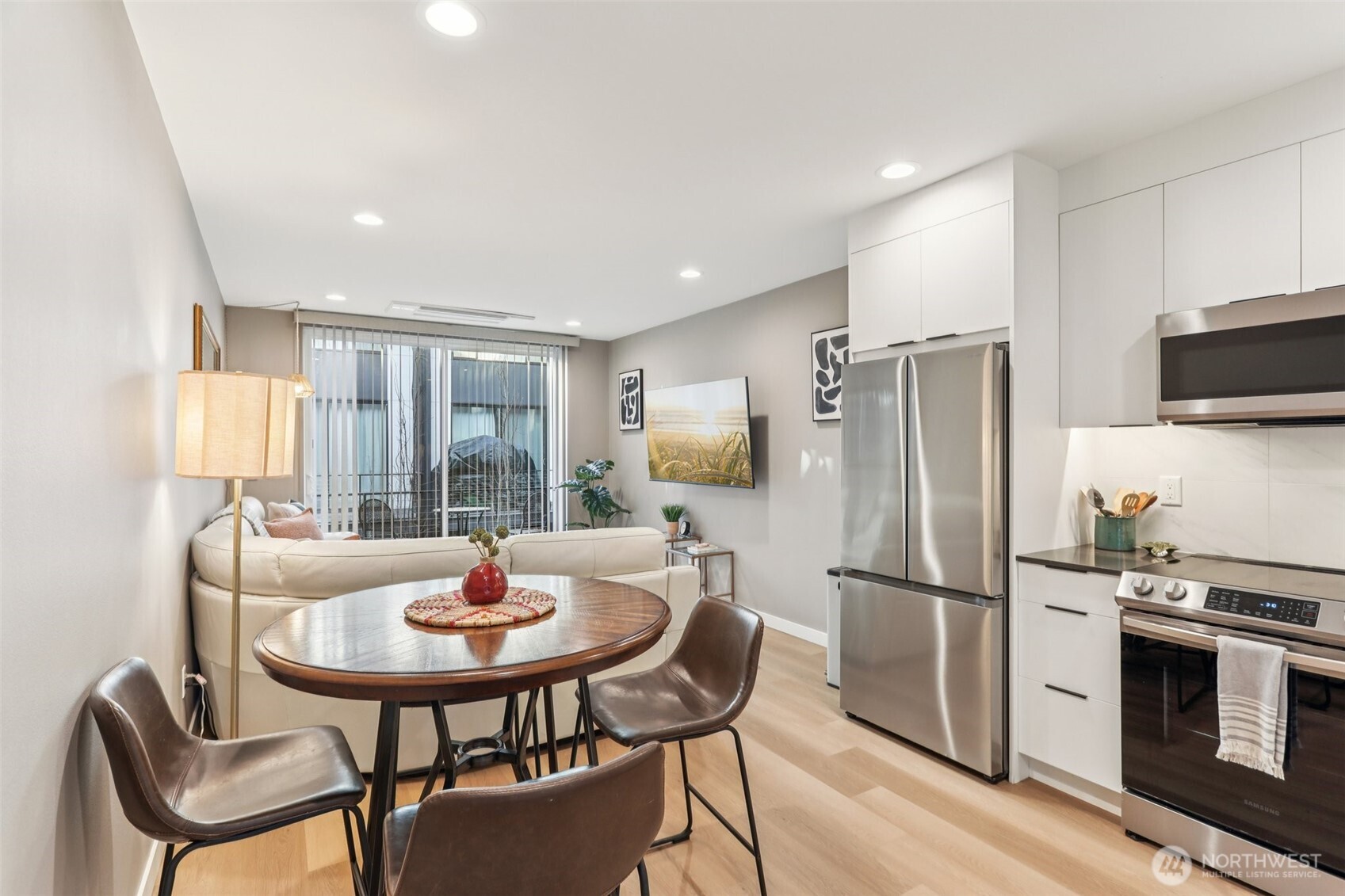 7514 43rd Avenue South, Unit B Seattle, WA 98118 - Photo 9 of 40 a kitchen with stainless steel appliances a refrigerator a stove a dining table and chairs