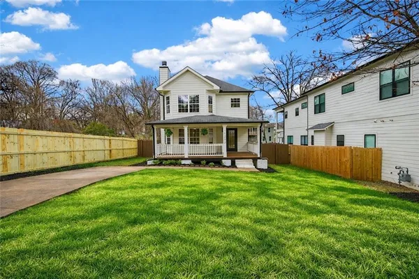 a view of an house with backyard space and balcony
