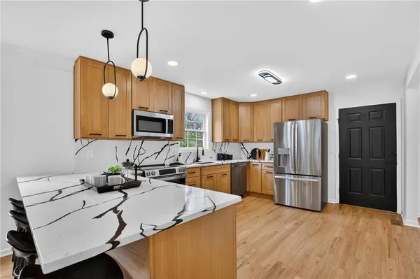 a kitchen with stainless steel appliances granite countertop a sink a stove and a wooden floors