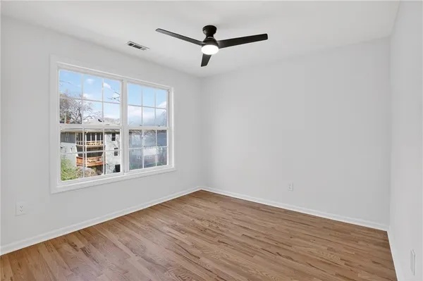 a view of an empty room with wooden floor