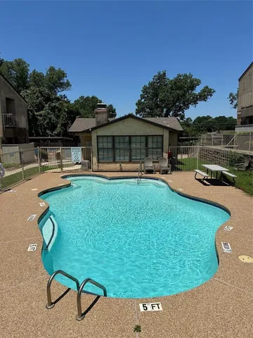 a view of a swimming pool with lounge chairs in patio