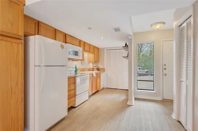 a white refrigerator freezer and a stove sitting inside of a kitchen