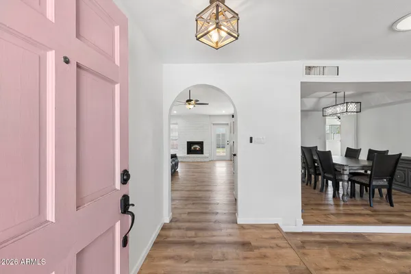 a view of a hallway to a livingroom with furniture wooden floor mirror and a chandelier