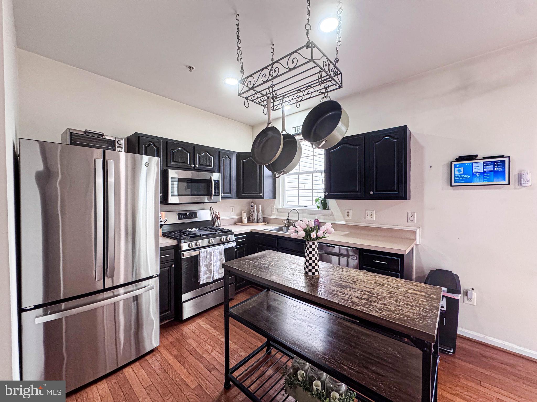 68 Millhaven Court Edgewater, MD 21037 - Photo 20 of 31 a kitchen with stainless steel appliances granite countertop a refrigerator a stove a sink dishwasher a dining table and chairs with wooden floor
