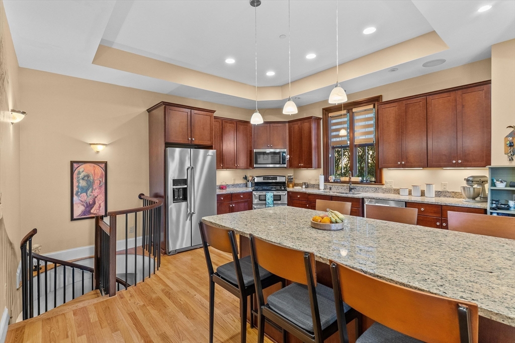 7 Winter Street, Unit 2 Salem, MA 01970 - Photo 8 of 42 a kitchen with stainless steel appliances granite countertop table chairs sink refrigerator and cabinets
