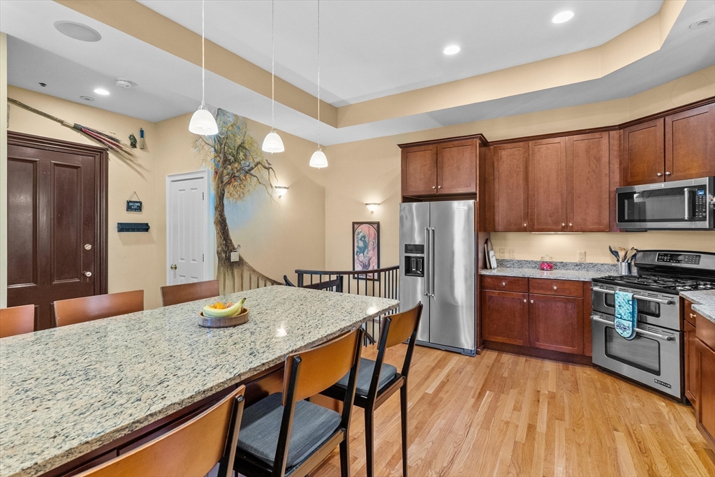 7 Winter Street, Unit 2 Salem, MA 01970 - Photo 9 of 42 a kitchen with stainless steel appliances granite countertop a kitchen island hardwood floor sink stove and refrigerator