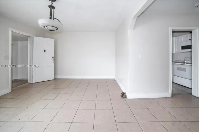 a view of a livingroom with an empty space cabinets and a window
