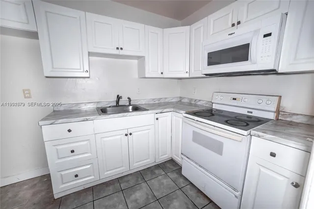 a kitchen with white cabinets stainless steel appliances and sink