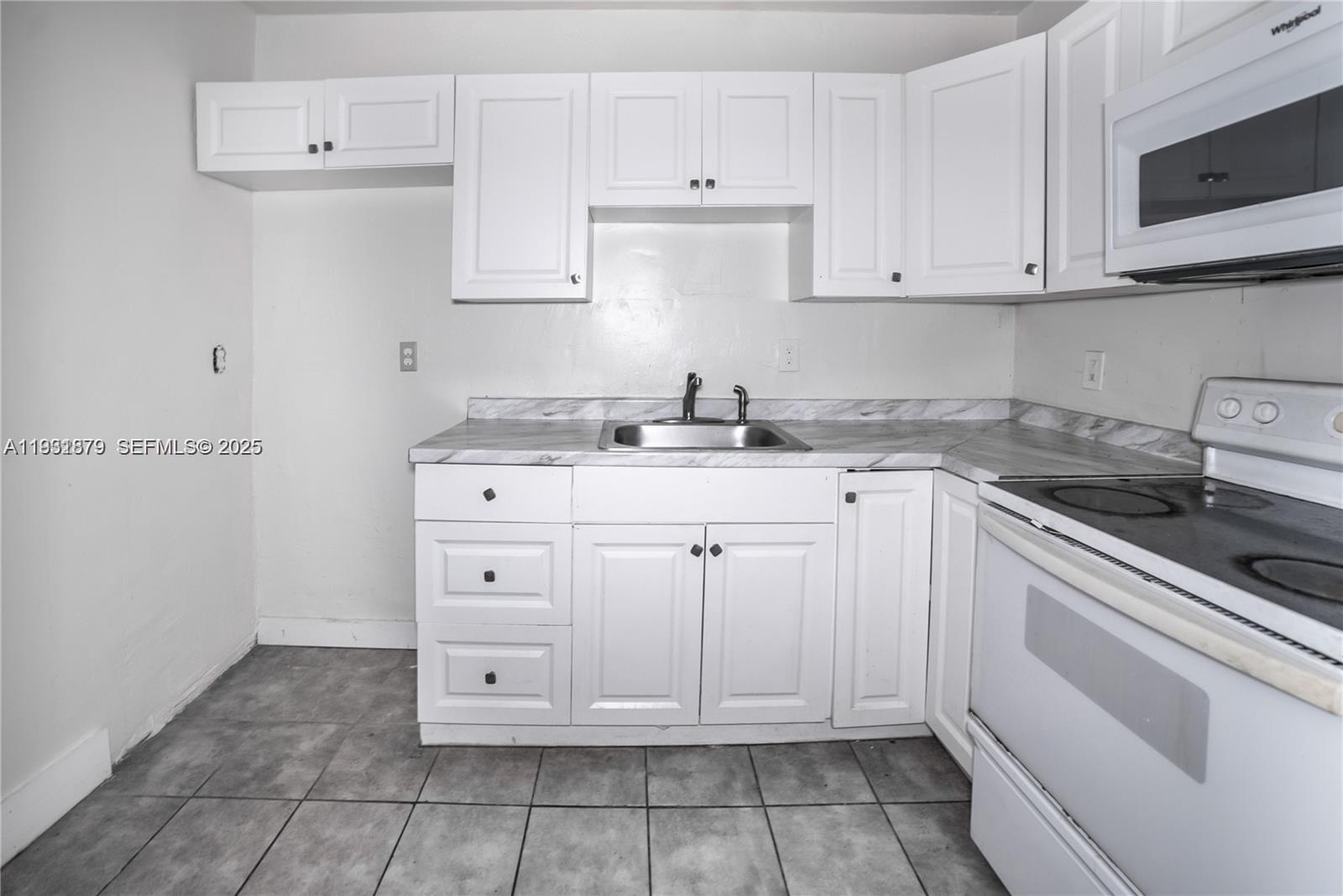 2501 Northwest 22nd Avenue Miami, FL 33142 - Photo 13 of 43 a white kitchen with granite countertop white cabinets