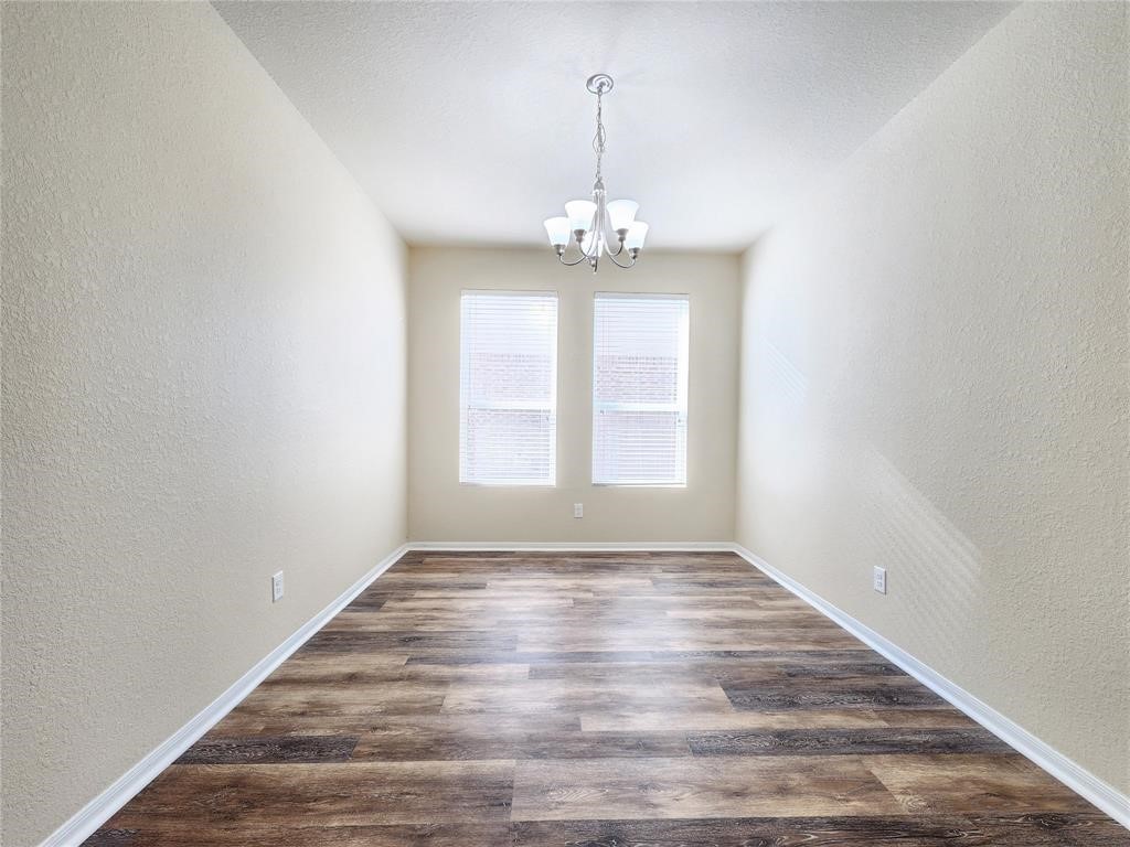 12507 Kings Pond Court Houston, TX 77044 - Photo 7 of 10 a view of an empty room with wooden floor and a window