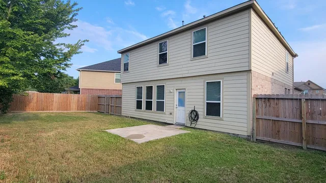 a view of a house with a yard and wooden fence