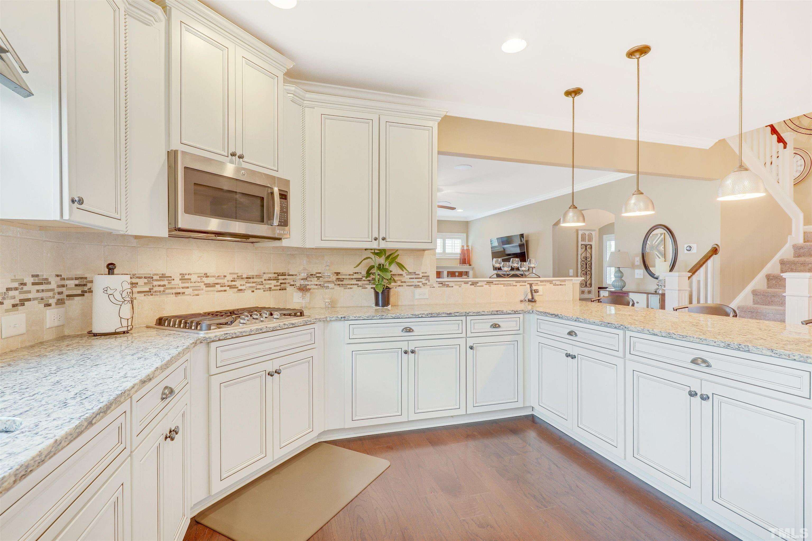 4312 Glengrove Road Raleigh, NC 27616 - Photo 14 of 50 a kitchen with kitchen island granite countertop white cabinets white stainless steel appliances with a sink and dishwasher