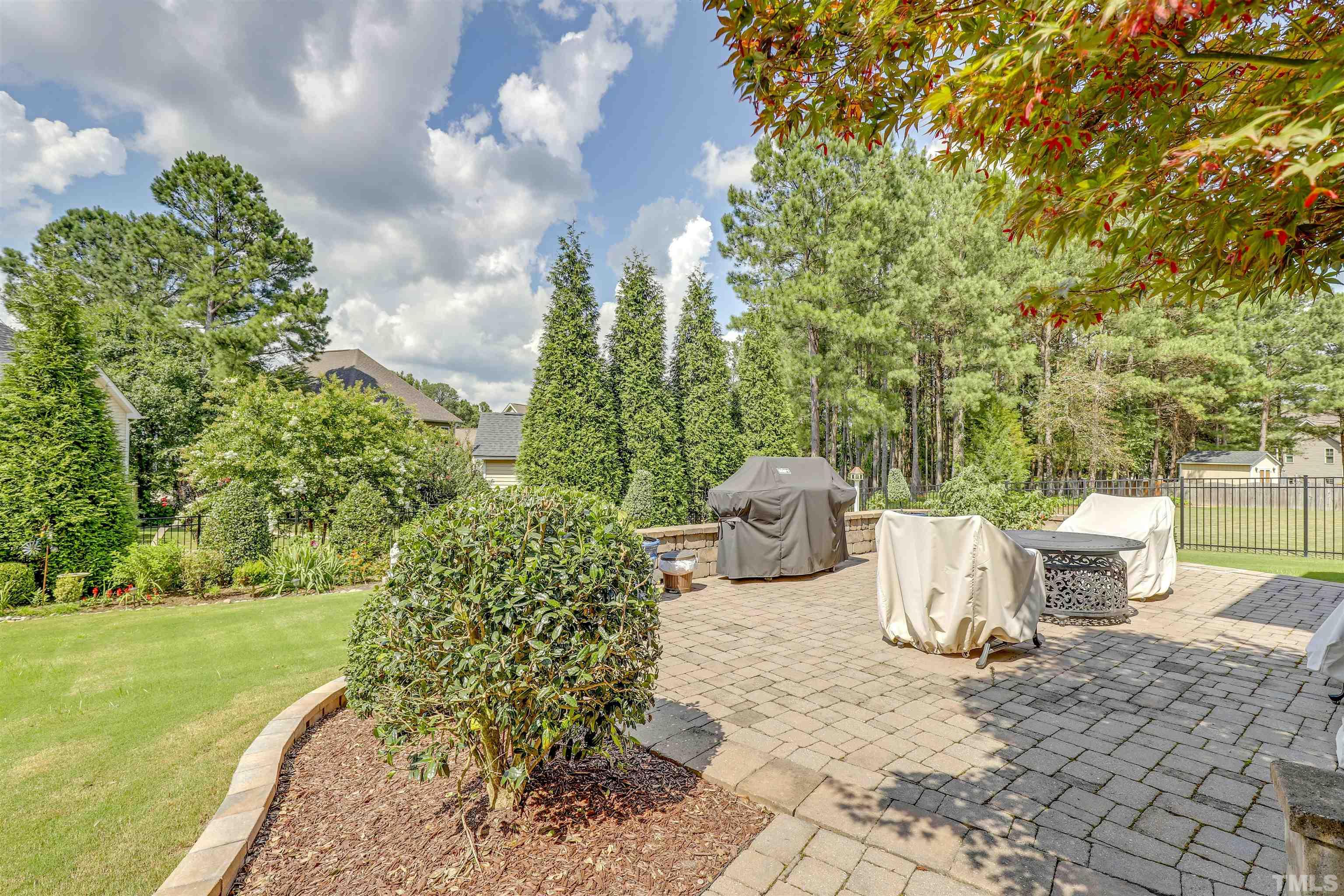 4312 Glengrove Road Raleigh, NC 27616 - Photo 42 of 50 a view of a patio with table and chairs plants and large trees