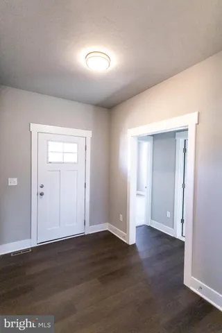 a view of an empty room with wooden floor & closet