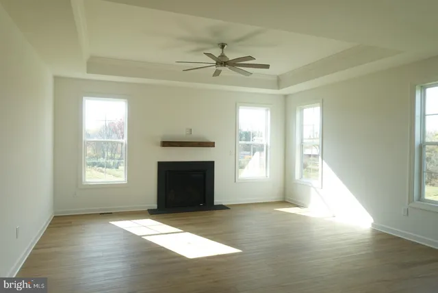 a view of an empty room with a fireplace and a window