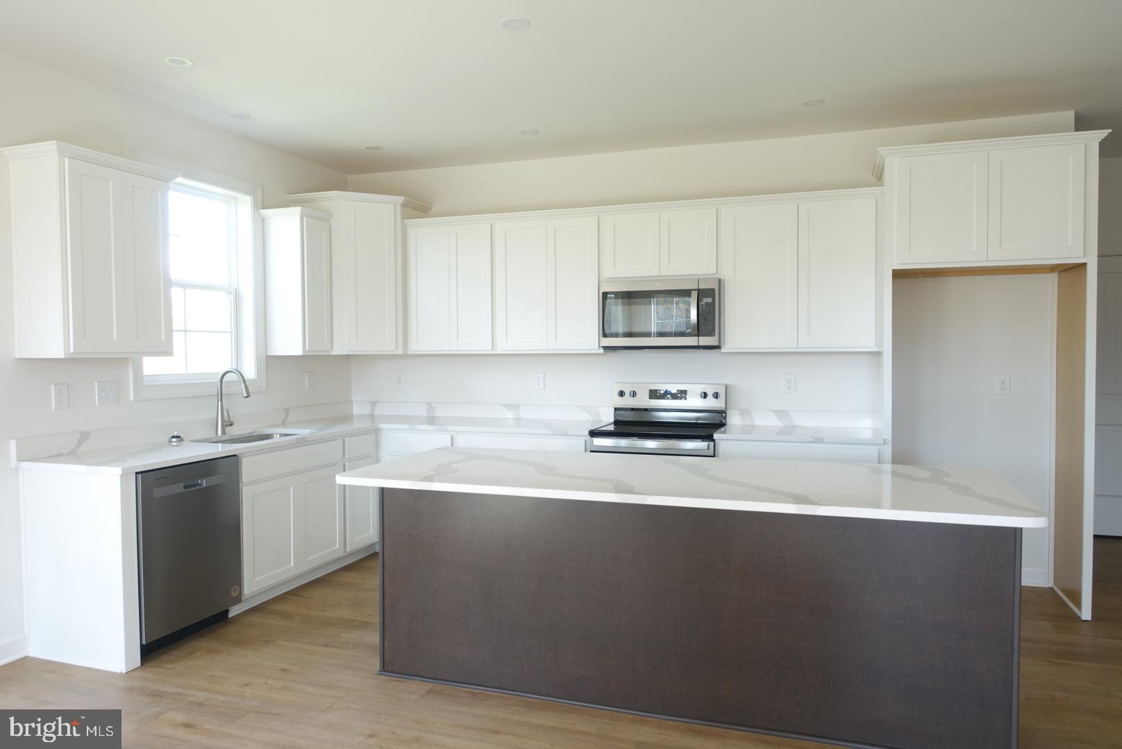 310 Steeple View Drive, Unit 18 Hanover, PA 17331 - Photo 7 of 24 a kitchen with stainless steel appliances a sink a stove a microwave a sink a refrigerator and cabinets
